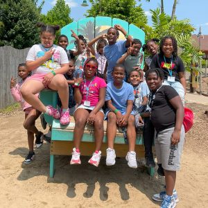 Students pose on a giant chair at the Zoo.