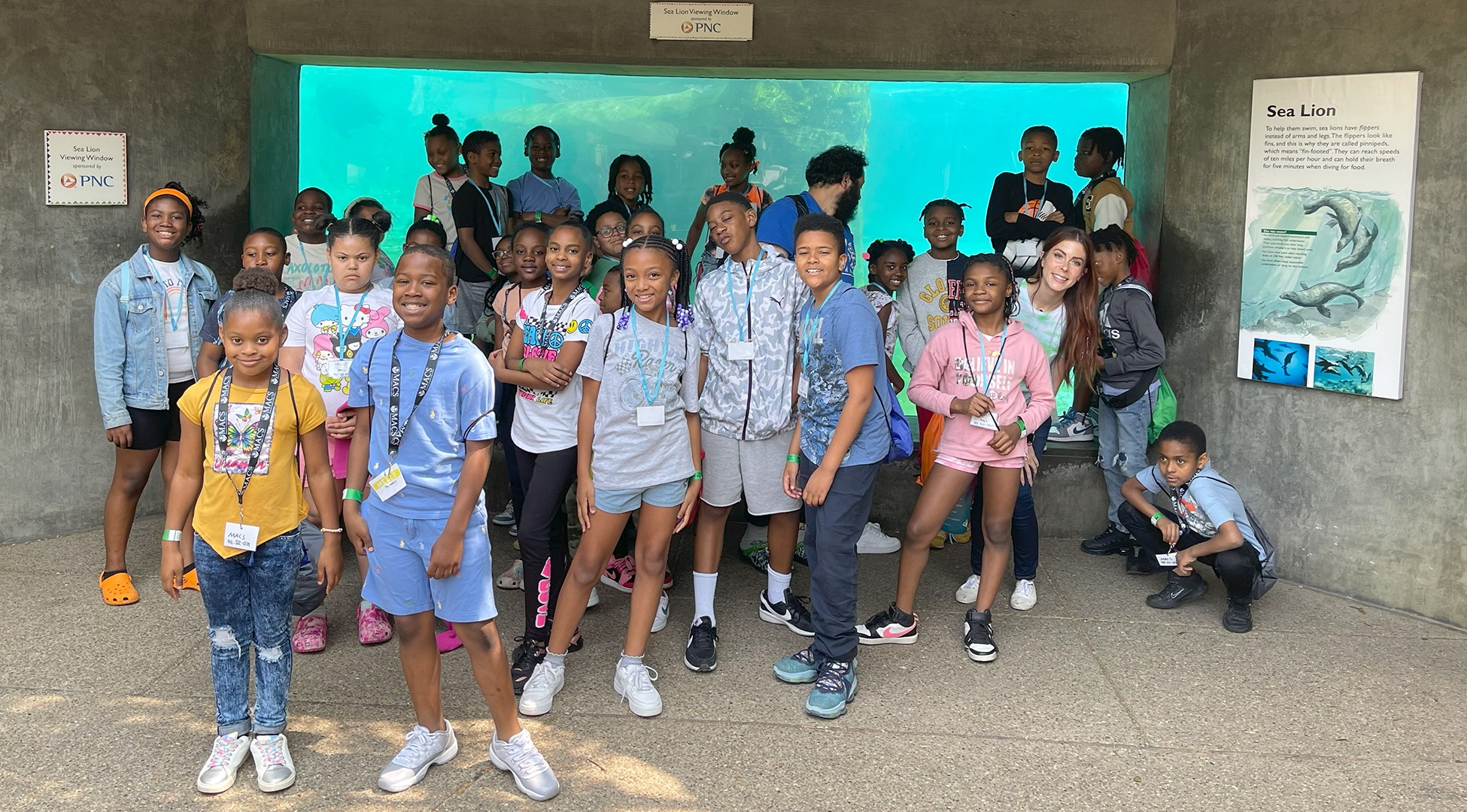 Students stand in front of a zoo exhibit