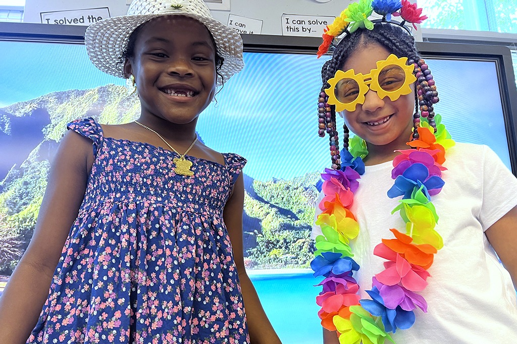 Two smiling students in colorful costumes.