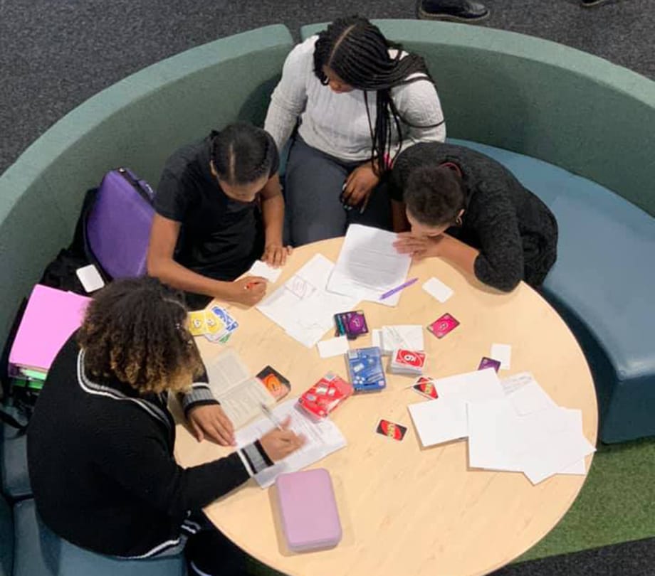 study at the round table Four female students study at a round table
