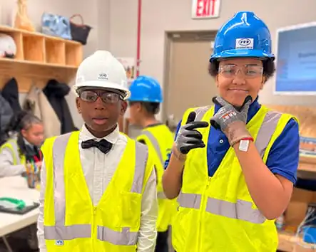 Two male students wearing hardhats. Two male students wearing hardhats.