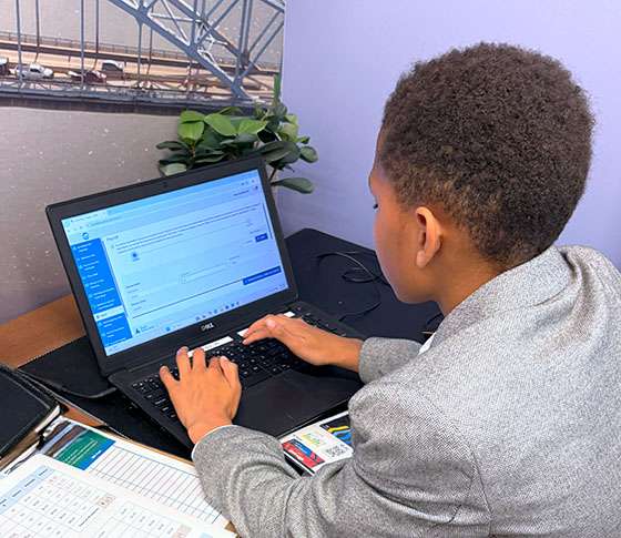 A MACS student works on on a laptop.