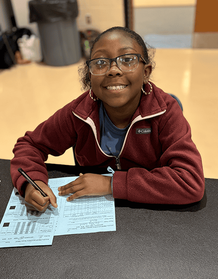 academic games student 1 female academic games student writing on paper