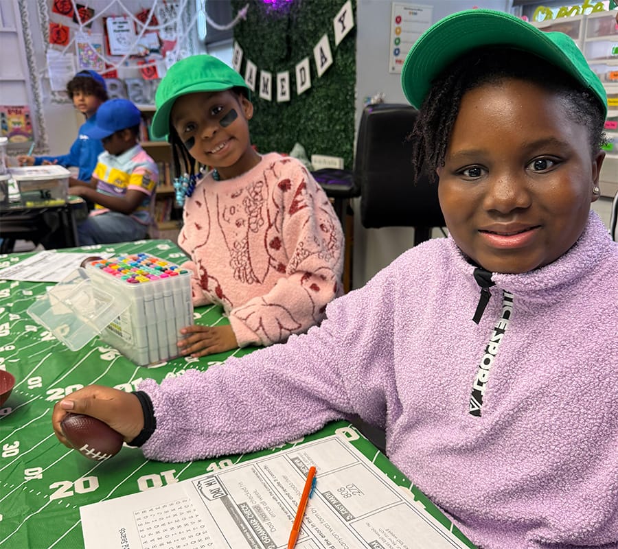 Two girls sit together and play a game.