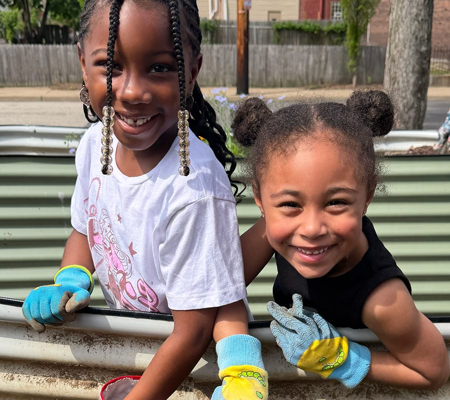 Two girls work in the MACS garden.